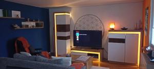 a living room with a couch and a television at FeWo Blaue Oase, Netflix, Massagesessel, Whirlpool Badewanne in Germersheim