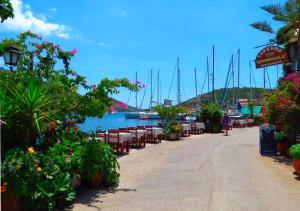 a walkway with tables and chairs next to a marina at Vlastaras Apartment in Sivota