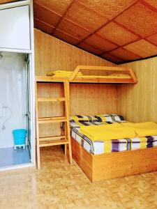 ein Schlafzimmer mit einem Etagenbett und einer Leiter in der Unterkunft The Himalaya Retreat Resort, Experience Nature in the Lap of Himalayas in Masuri