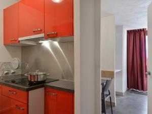 een keuken met oranje kasten en een wastafel bij Appartement Plagne Bellecôte, 2 pièces, 5 personnes - FR-1-181-2014 in La Plagne Tarentaise