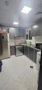 eine große Küche mit Küchengeräten und Schränken aus Edelstahl in der Unterkunft Luxury Private Room in Sharjah in Schardscha
