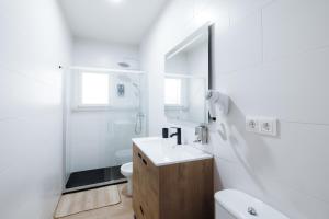 Un baño blanco con lavabo y ducha en La Casita de la Gula, en Jarandilla de la Vera 23 fotos más