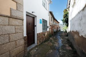 Une allée avec une porte dans un bâtiment dans l'établissement La Casita de la Gula, à Jarandilla de la Vera