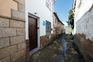 um beco com uma porta num edifício em La Casita de la Gula em Jarandilla de la Vera