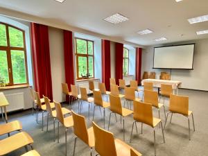 a lecture room with chairs and a whiteboard at Penzion Praděd Thamm in Zlaté Hory