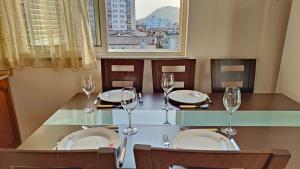 a dining table with wine glasses and plates on it at Appartamento Bruno spazioso e centrale in Shkodër