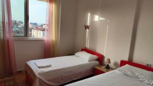 a hotel room with two beds and a window at Appartamento Bruno spazioso e centrale in Shkodër