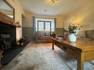 een woonkamer met een bank en een salontafel bij Rosemount Cottage ONE- Highland Cottage in Garve