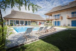 a group of chairs sitting around a swimming pool at Limanul Resort - Danube Delta in Chilia Veche