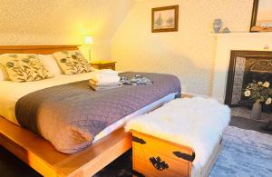 a bedroom with a bed and a fireplace at Rosemount Cottage ONE- Highland Cottage in Garve
