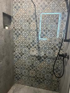 a bathroom with a shower with a tile wall at Varsovia Tower in Warsaw