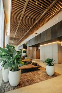 a lobby with two large potted plants and a couch at Gale Miami Hotel & Residences in Miami