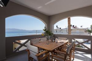 a dining room with a table and views of the ocean at Zoe's Place - 2 BD Beachfront Apartment in Kissamos