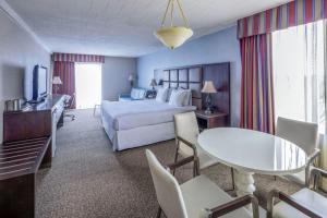 a hotel room with a bed and a table and chairs at Radisson Hotel Hauppauge-Long Island in Hauppauge