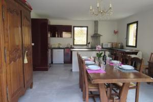 a kitchen with a wooden table and a dining room at Maison Spacieuse situation idéale au calme in Bouillac