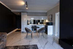 a kitchen with two chairs and a table in it at City Nest:Heart of Linksfield II in Johannesburg