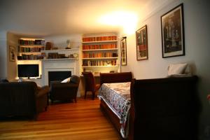 a living room with a fireplace and a table and chairs at Garden flat in a quiet Camden spot in London