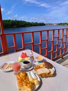 a table with a tray of breakfast food on a boat at Hotel Beira Rio Preguiças in Barreirinhas