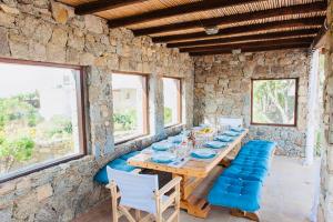 a dining room with a wooden table and chairs at Dreamy Boho 5bed Villa with Pool and Ocean View in Mikonos