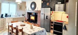 BossetにあるVilla de 3 chambres avec piscine partagee terrasse amenagee et wifi a Bossetのテーブル付きのキッチン、暖炉付きのキッチン