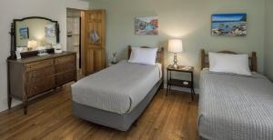 um quarto com 2 camas, uma cómoda e um espelho em The Craignair Inn & Causeway Restaurant em Spruce Head