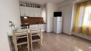 cocina con mesa y nevera blanca en Mire Apartment, en Durrës