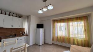 cocina con nevera blanca y ventana en Mire Apartment, en Durrës