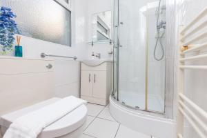 a white bathroom with a shower and a toilet at GuestReady - Interiores pitorescos em Brighton in Brighton & Hove