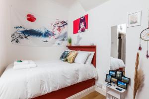 - une chambre avec un lit blanc et une tête de lit rouge dans l'établissement GuestReady - Interiores pitorescos em Brighton, à Brighton et Hove