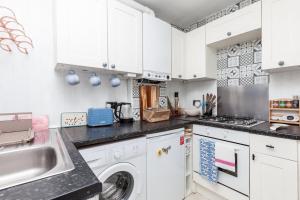 a kitchen with white cabinets and a dishwasher at GuestReady - Interiores pitorescos em Brighton in Brighton & Hove