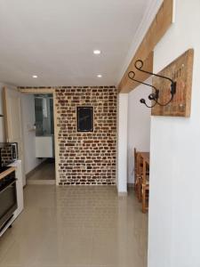 een woonkamer met een bakstenen muur en een keuken bij Logement 