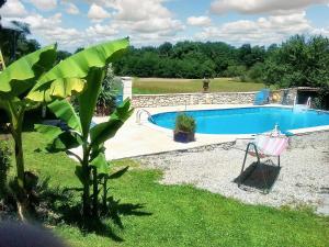 een zwembad in een tuin met een tuin bij Gîtes spacieux en Dordogne avec piscine partagée et jardin 140 m² in Bosset
