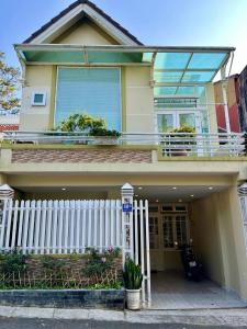 a white fence in front of a house at MiAnnA Homestay in Xuan An