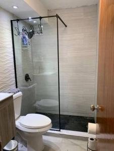 y baño con aseo y ducha acristalada. en Condado 1 bedroom Apt w/ View, en San Juan