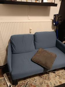 a blue couch in a living room with a pillow at La Maison Bleue - La Haye in The Hague