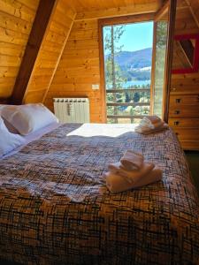 um quarto com uma cama grande e toalhas em Chalet Natura la taverna dei 3 porcellini em Cavaliere