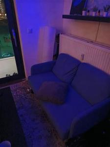ein Wohnzimmer mit einem Sofa und einem lila Licht in der Unterkunft La Maison Bleue - La Haye in Den Haag