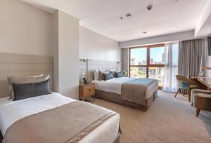 a hotel room with two beds and a desk at HOTEL KONKE MAR DEL PLATA in Mar del Plata