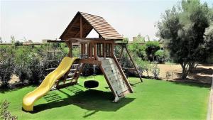 LUXUEUSE VILLA AVEC PISCINE PRIVEE PROCHE D'AGADIR في أغادير: ملعب مع زحليقة على عشب أخضر