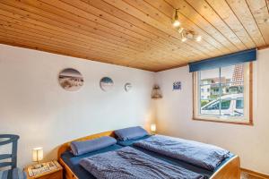 a bed in a room with a wooden ceiling at Ferienhaus Sonnenblumen in Boltenhagen