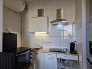 a small kitchen with a sink and a microwave at Apartment close to Lyon and Parc de Parilly in Saint-Priest