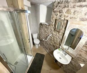 Un baño de piedra con lavabo y ducha. en Commanderie Vue Panoramique 2 chambres, en Le Poët-Laval 20 fotos más