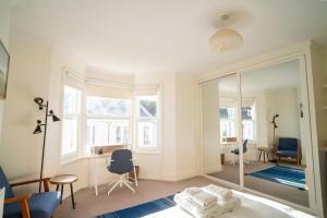 a living room with a mirror and blue chairs at GuestReady - Kemptown Coastal Comfort in Brighton & Hove