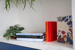 three books sitting on top of a shelf at GuestReady - Kemptown Coastal Comfort in Brighton & Hove