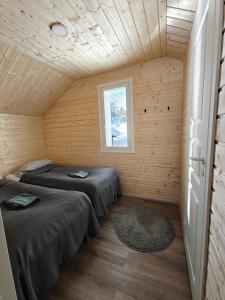 two beds in a room with a window at Aava Sky Village in Aavasaksa
