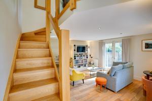 uma sala de estar com escadas que levam até ao segundo andar em South Stable at Hallsteads: Cosy Stone Cottage, with Parking em Alnmouth