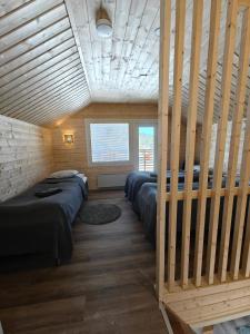 a room with four beds in a wooden room at Aava Sky Village in Aavasaksa