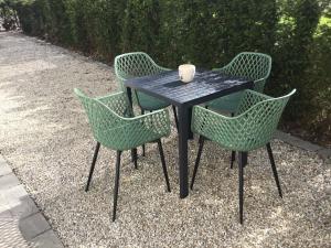 een zwarte tafel met drie stoelen en een beker erop bij Gezellige Studio met terras in Oudenaarde
