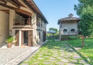 une maison avec un chemin en pierre à côté d'un bâtiment dans l'établissement Casale Gambini, à Quattro Castella