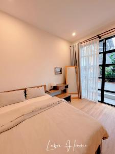 a bedroom with a bed and a large window at Labri Home Da Lat in Da Lat